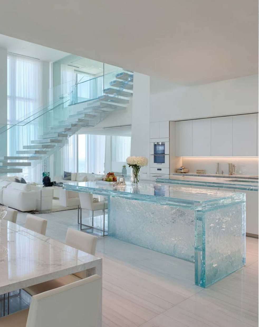 Ice-inspired glass kitchen island and glass staircase inside an Ice Beach residence